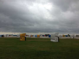 Strandkörbe auf Wiese sowie Sand