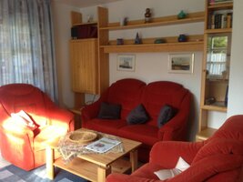 Sitzecke (zwei Sessel, ein Sofa, ein Holztisch) im Wohnzimmer