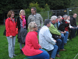 Zehn Teilnehmer (drei stehen, sieben sitzen auf der Bank)