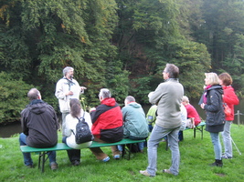 Der Wupper-Tell Ernst Nowak hält seinen Vortrag vor zehn Teilnehmern. Im Hintergrund fließt die Wupper.